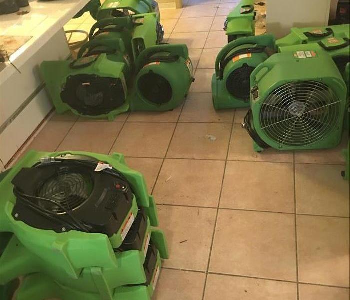 green air movers on a tile floor