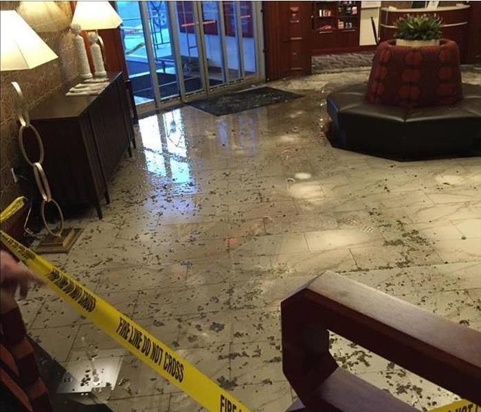 dirty debris on flooded tile floor in lobby